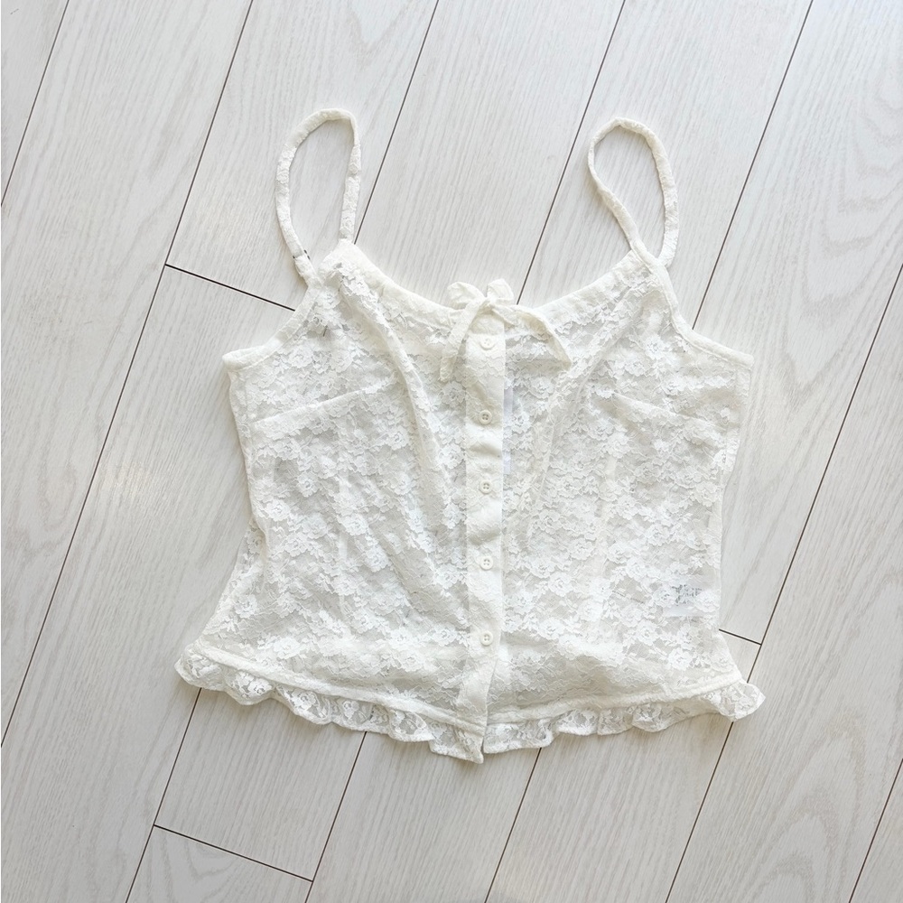 White lace cami top with button front and ruffle hem from Brandy Melville